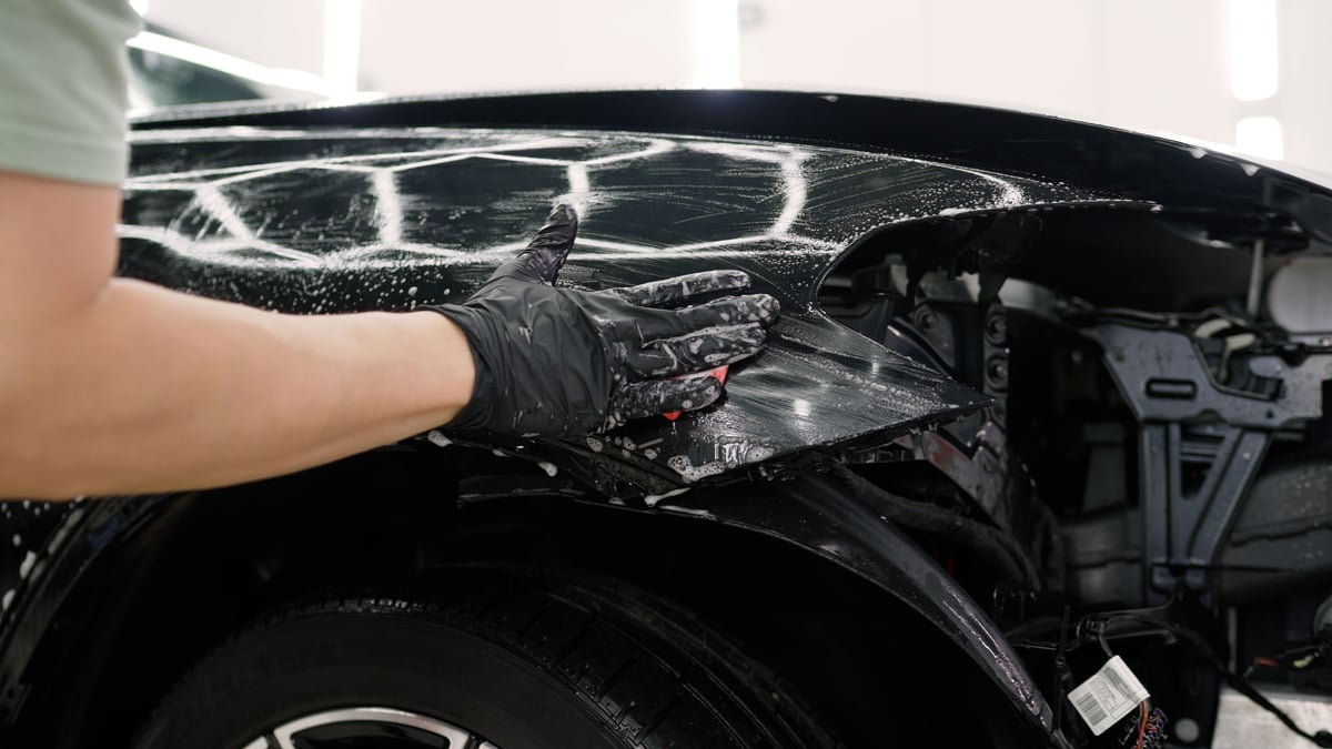 Detailer cleaning a vehicle with sponge